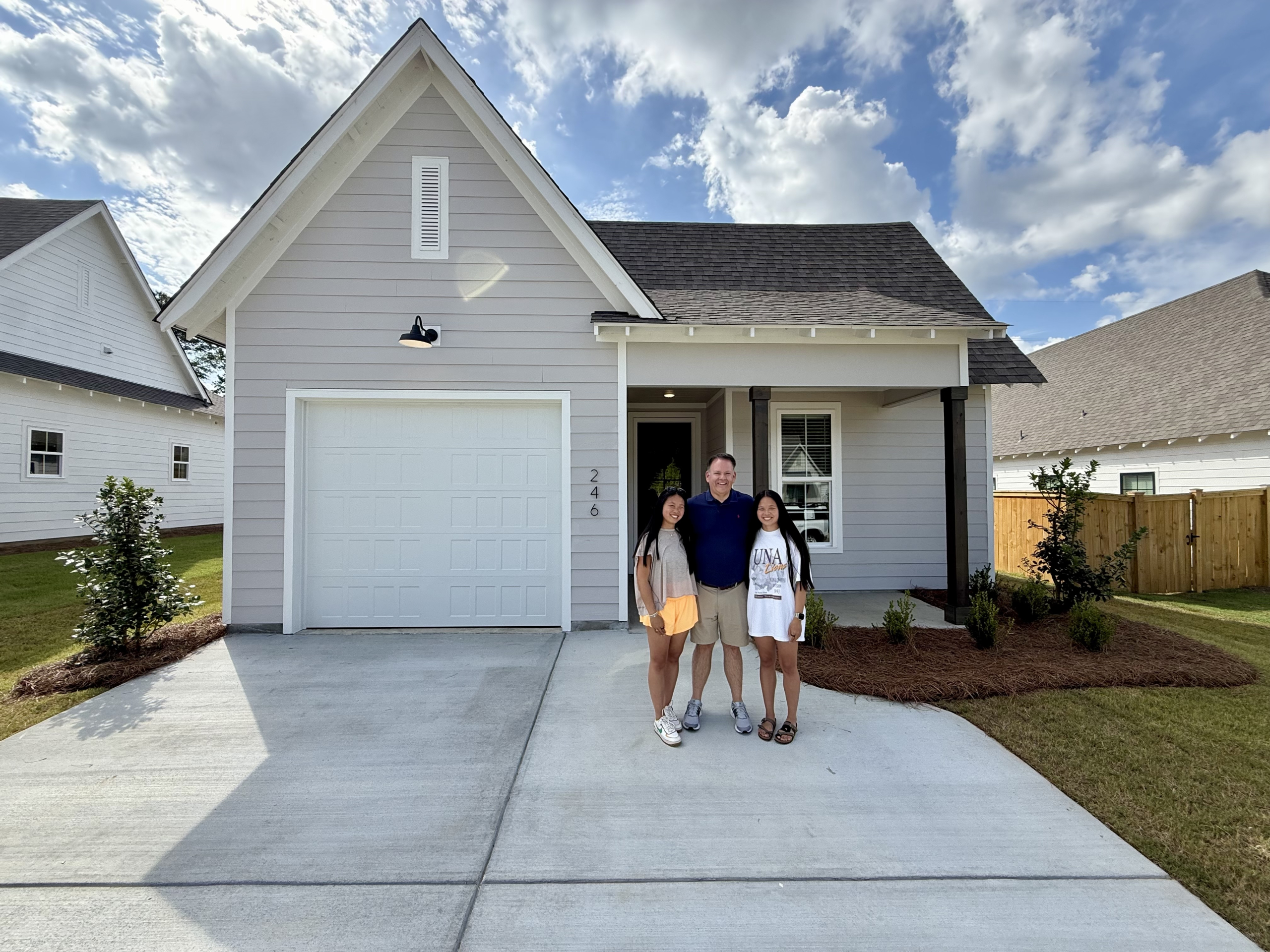 Happy Hayley Real Estate clients in front of their new home